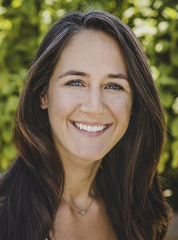 Headshot of dark haired women standing outside