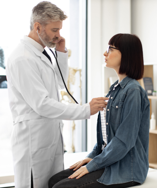 Doctor using a stethoscope to check a patient's chest. For a visual tip on respiratory health in high pollution.